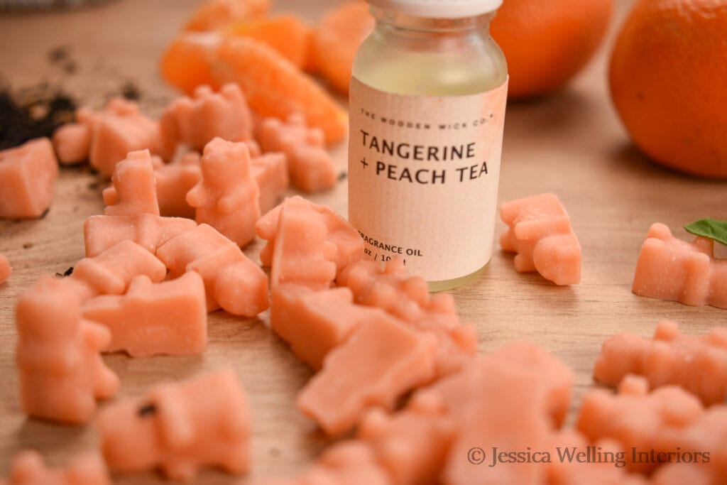 light orange gummy bear shaped wax melts with a bottle of Tangering & Peach Tea fragrance oil