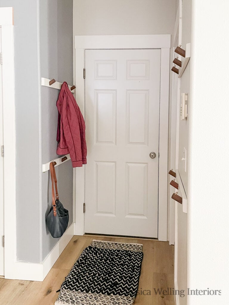 entryway with wall-mounted coat racks on both sides of the door
