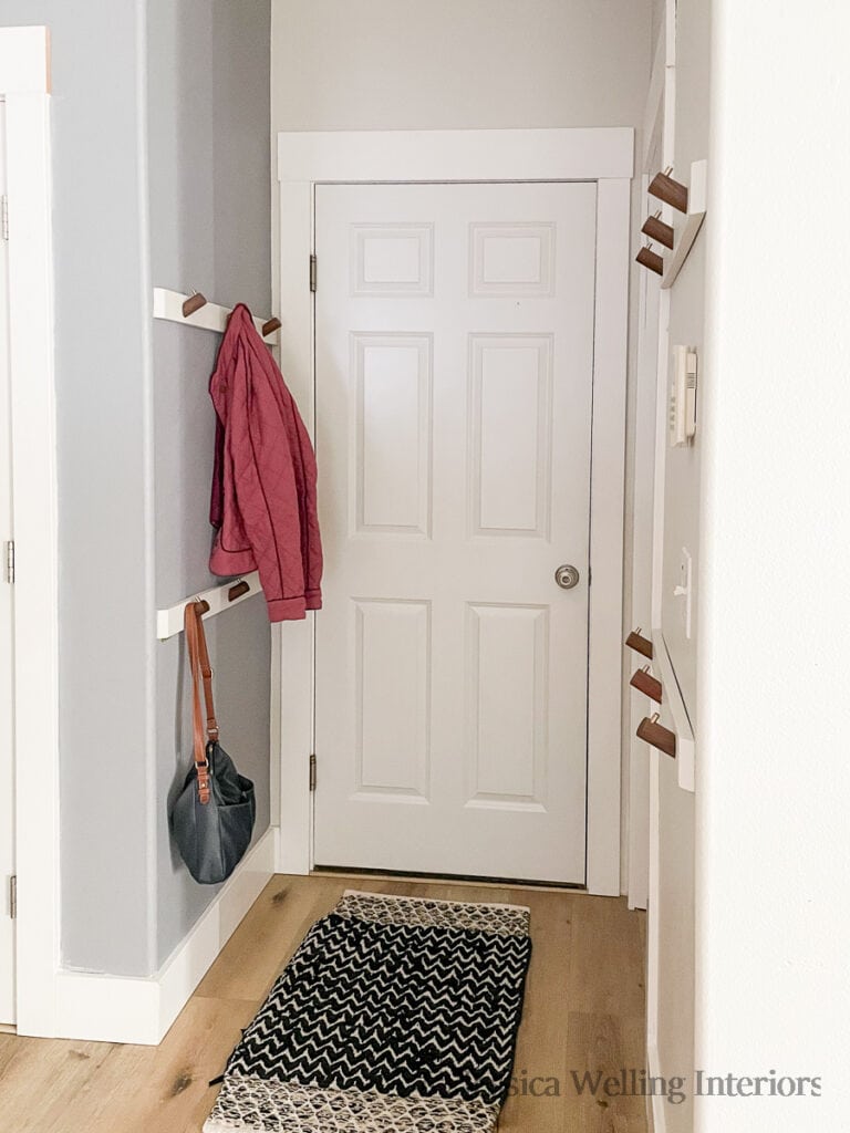 garage entryway with 4 wall mounted coat racks