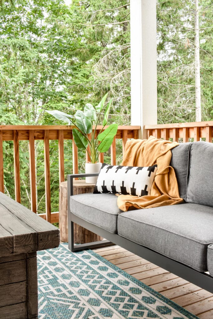 deck with modern outdoor sofa and a black and white patterned outdoor throw pillow