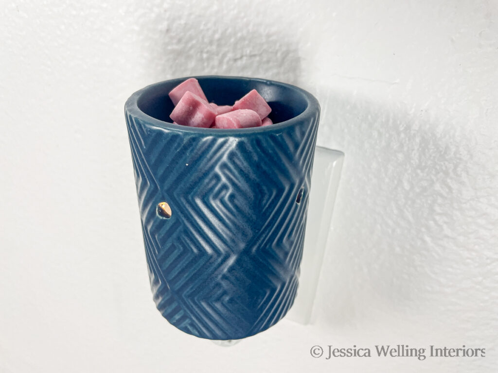 close up of a blue plug-in wax melt warmer with pink heart-shaped wax melts