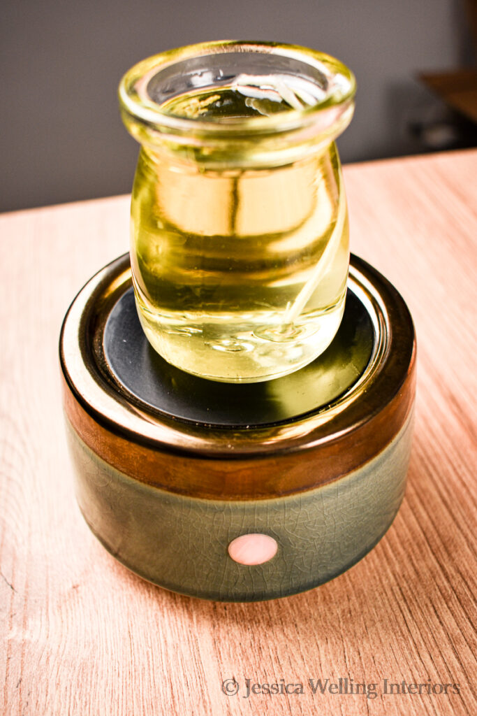 close-up of a wax melter with a melted candle sitting on top of it