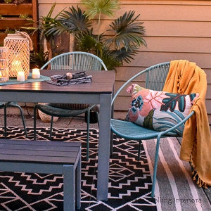 Boho patio makeover with an outdoor dining table, outdoor rug, and pillows