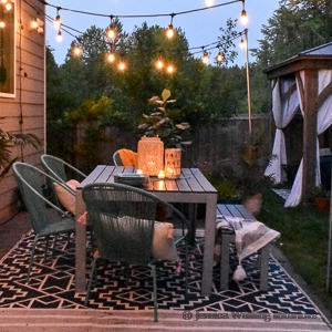 low light photo of patio with dining table and glowing string lights