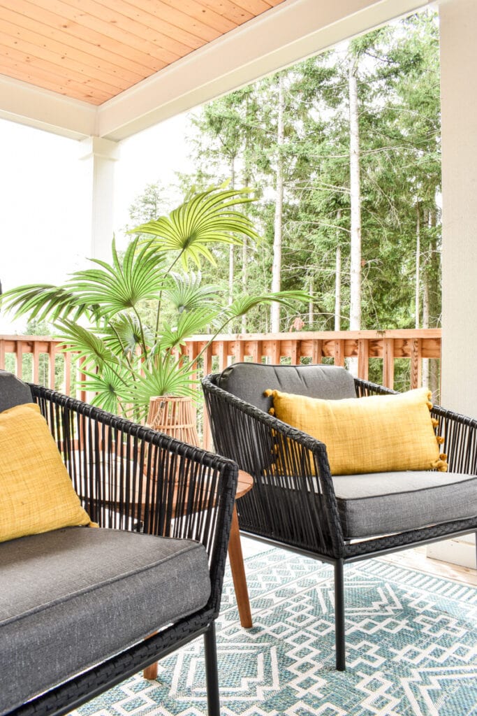 outdoor living room with two modern chairs and yellow outdoor pillows