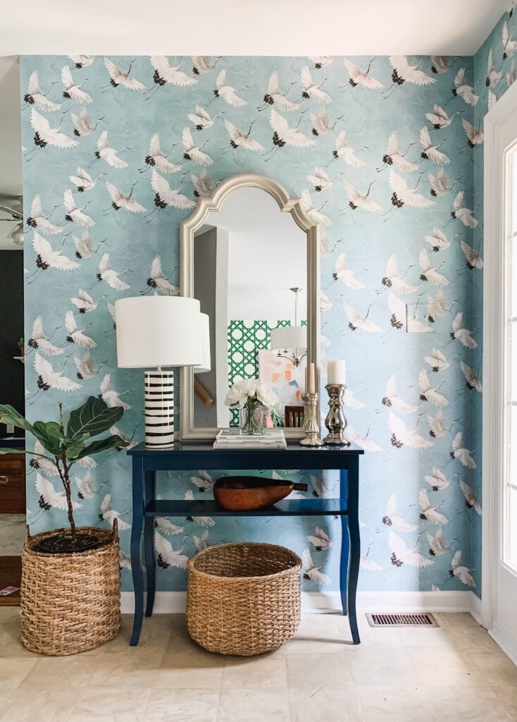 entryway with a table and scalloped mirror