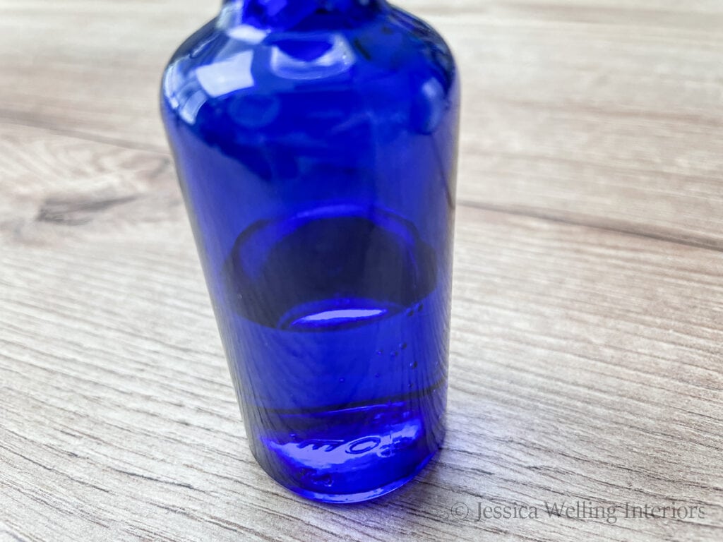 close-up of blue glass bottle 1/2 full of witch hazel