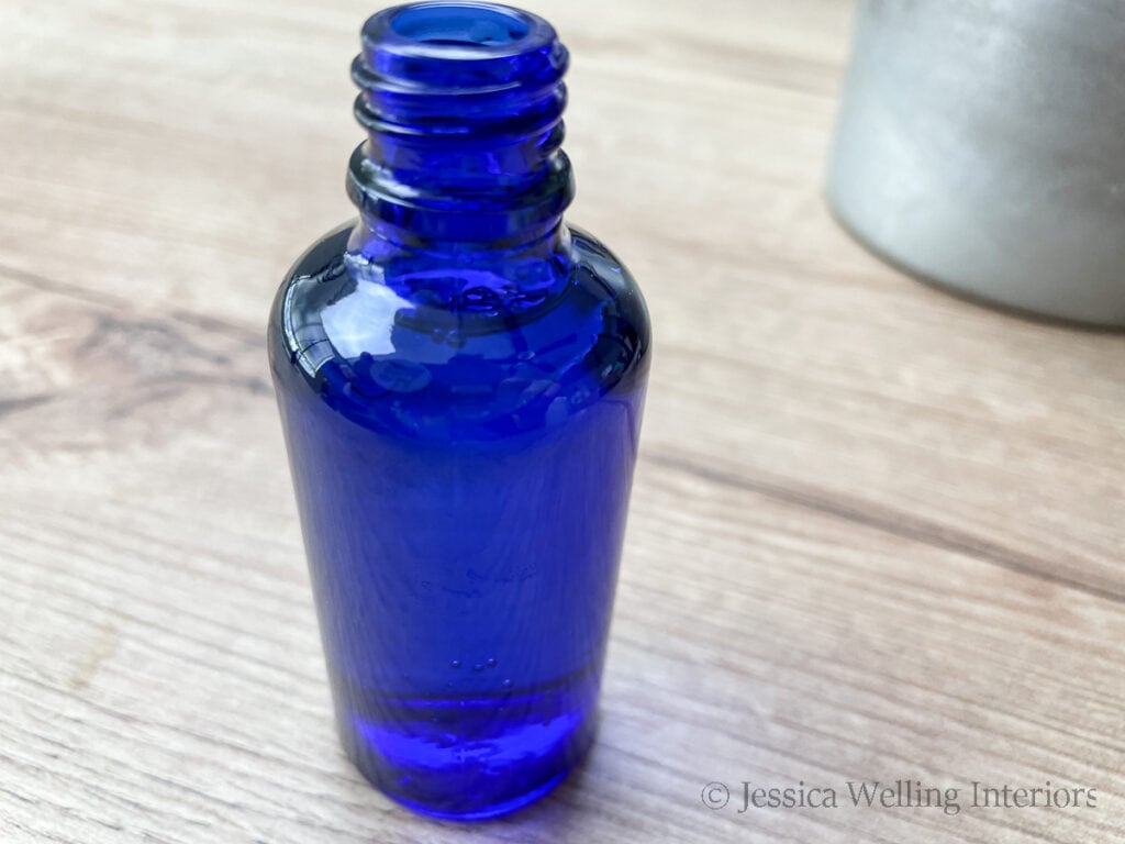 close-up of blue glass bottle full of DIY room spray