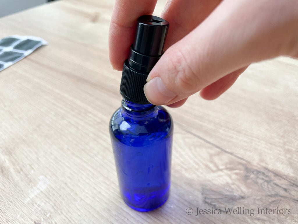 hand putting the spray cap onto a small  spray bottle