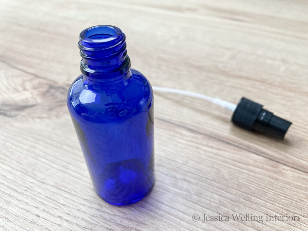 close up of empty blue glass spray bottle, ready to be filled with DIY room spray