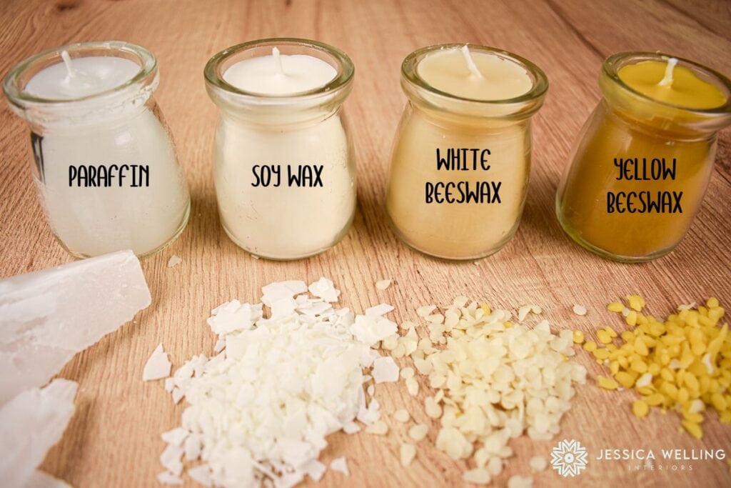 four candles lined up, each made with a different type of wax- paraffin, soy wax, white beeswax, and yellow beeswax