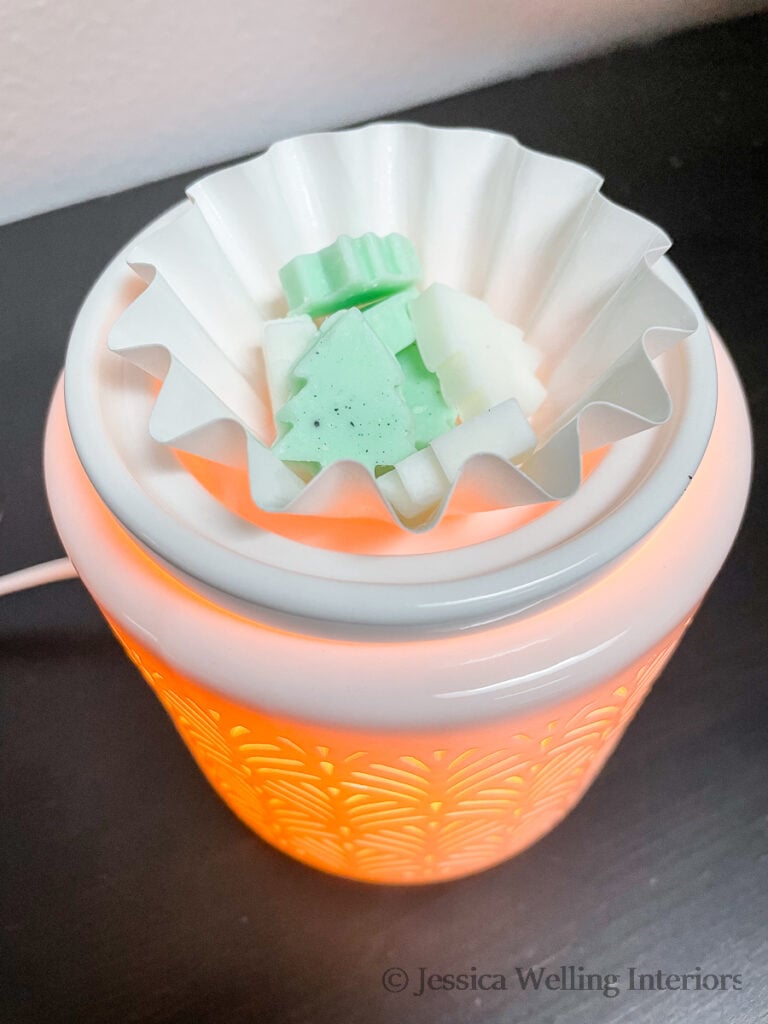close-up of a white wax warmer with Christmas tree-shaped wax melts inside it