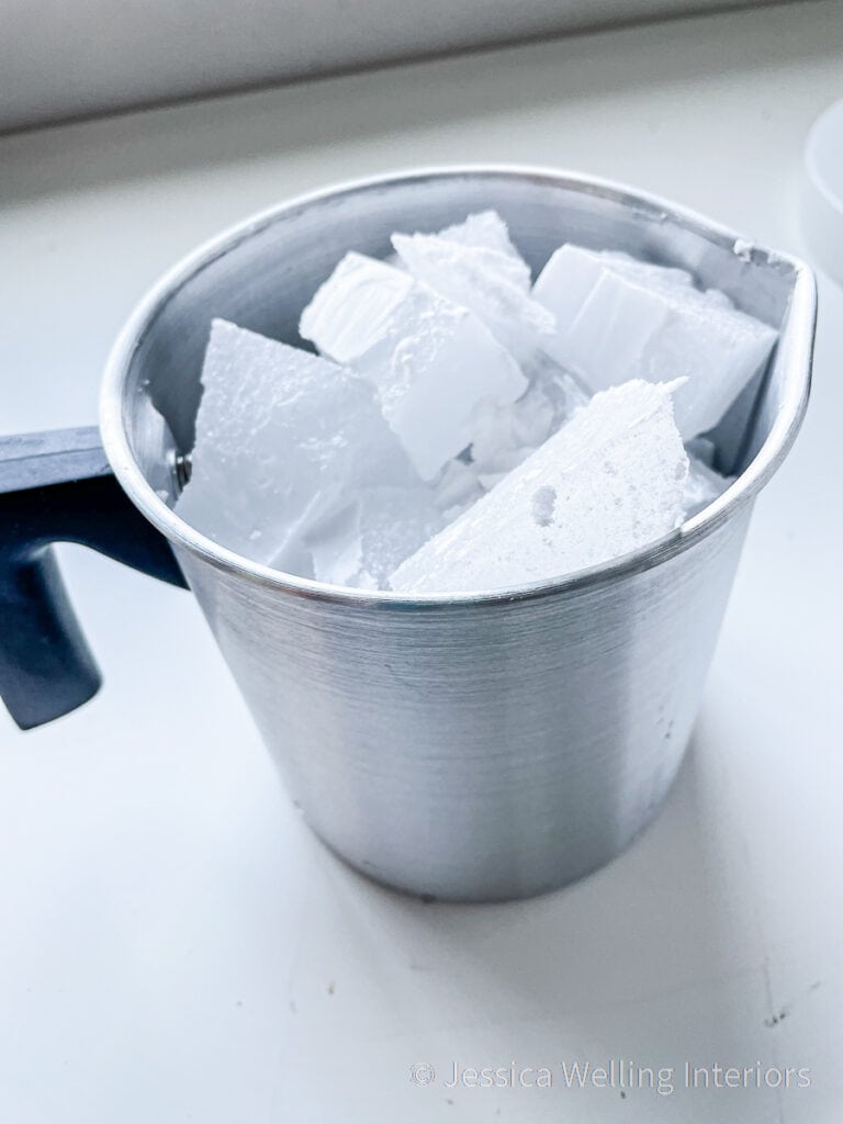 metal pitcher filled with pieces of paraffin, ready to be melted to make candles