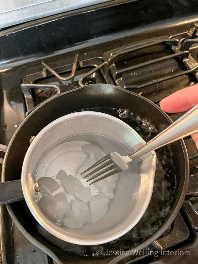 overhead view of a double boiler on the stove melting paraffin wax for candle making