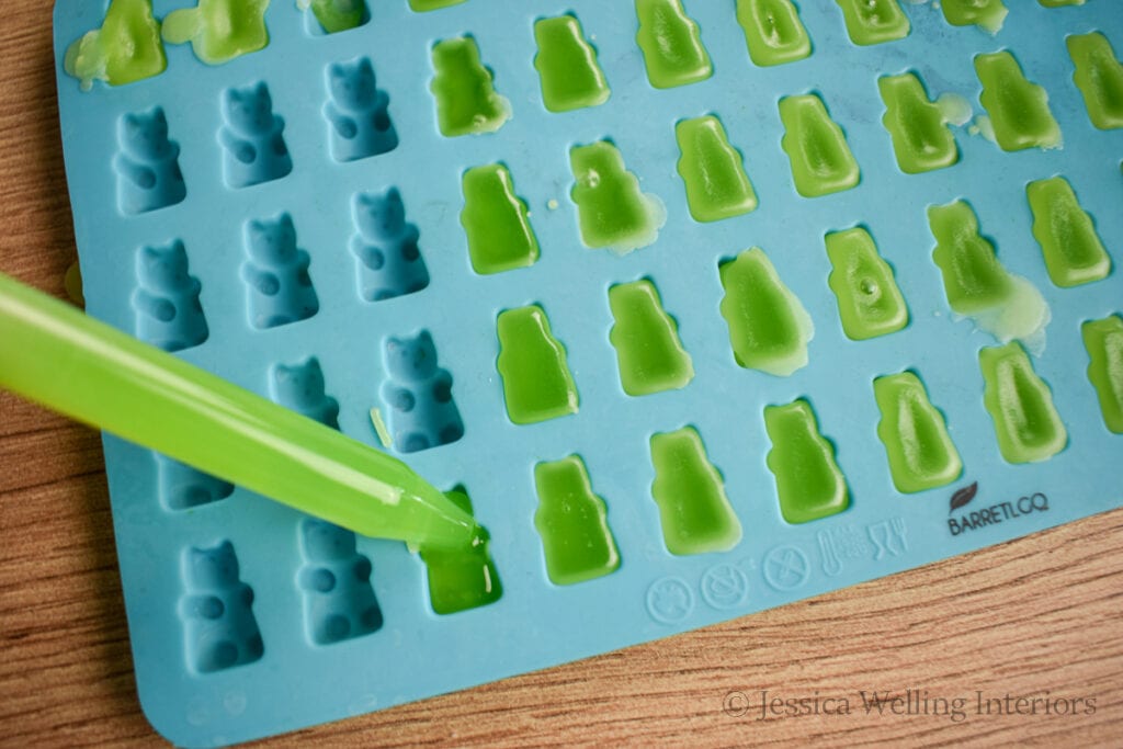 eye dropper filling a silicone mold with hot wax to make wax melts