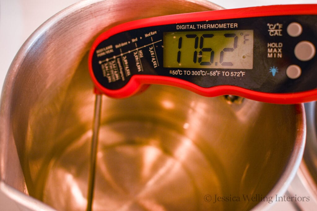 digital thermometer in metal pitcher of melted wax