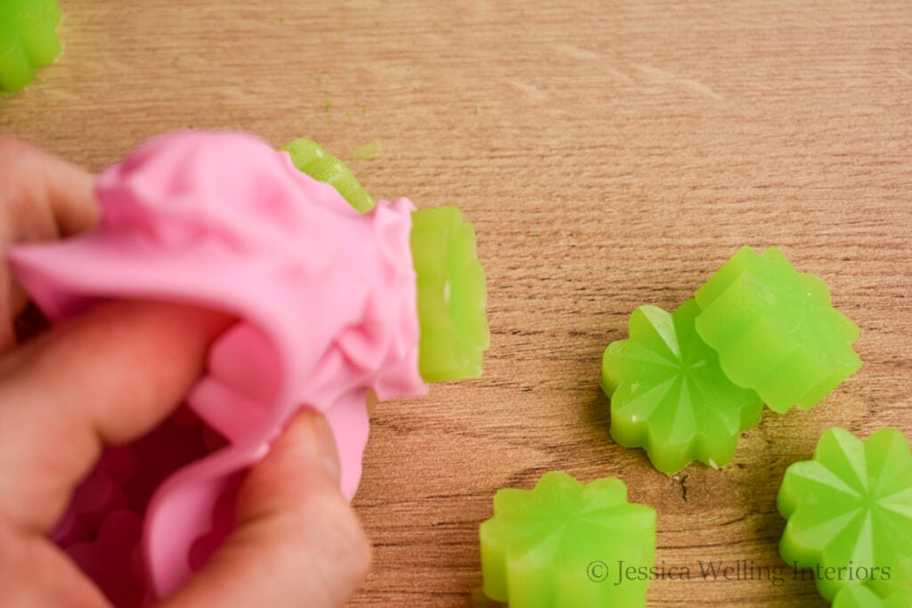 hands removing wax melts from a silicone mold