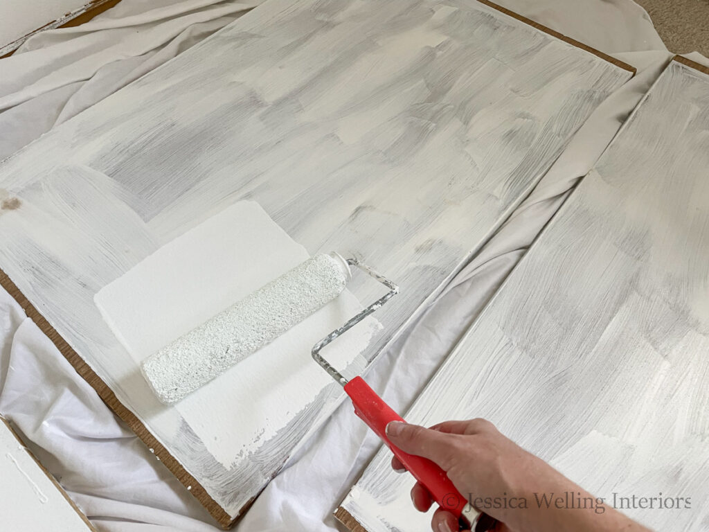 deep pantry shelves being painted white with a paint roller