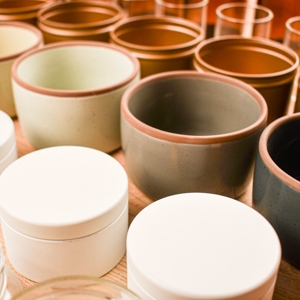 rows of candle jars and tins lined up on a countertop