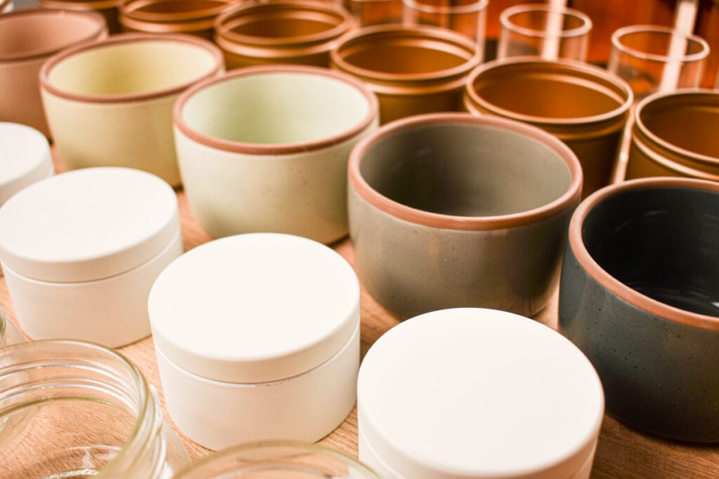 rows of candle vessels- jars. tins and ceramic ramekins