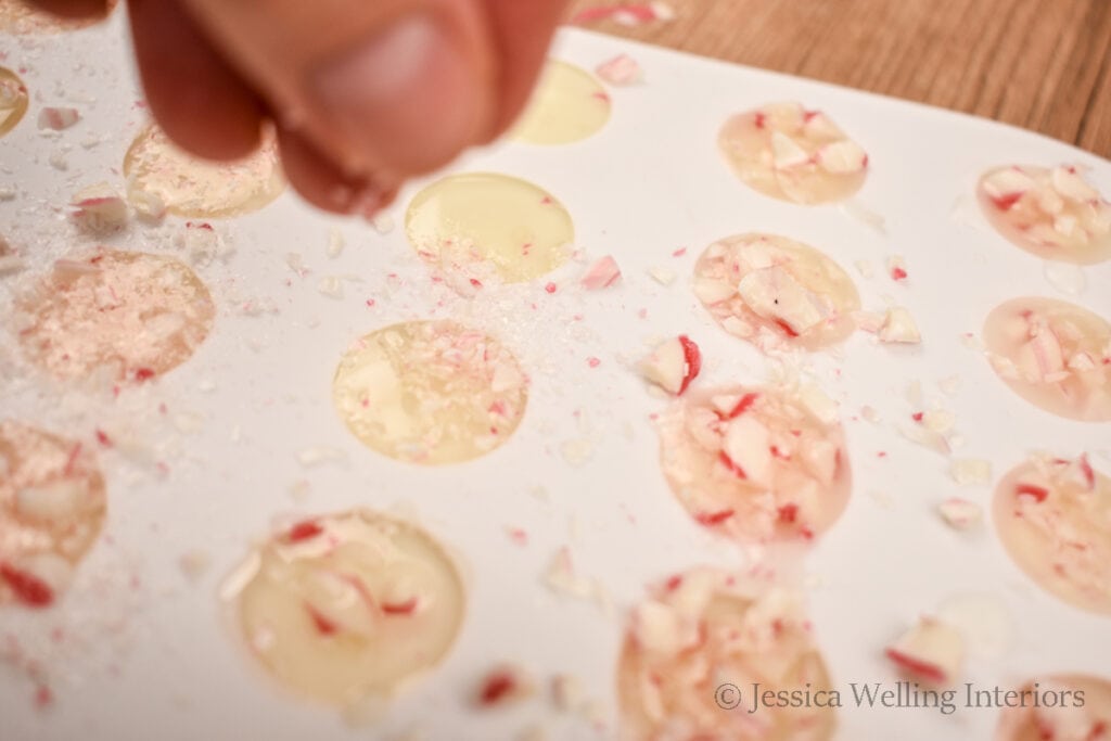 hand sprinkling bits of candy cane into a wax melts