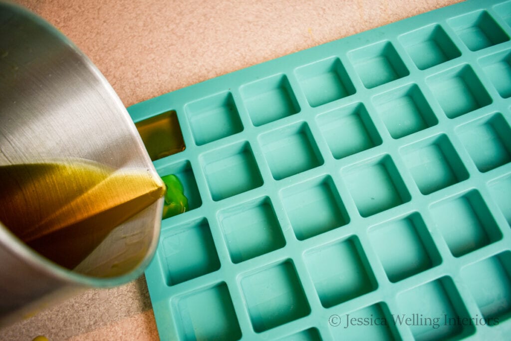 hot beeswax being poured into a silicone mold to make diy wax melts