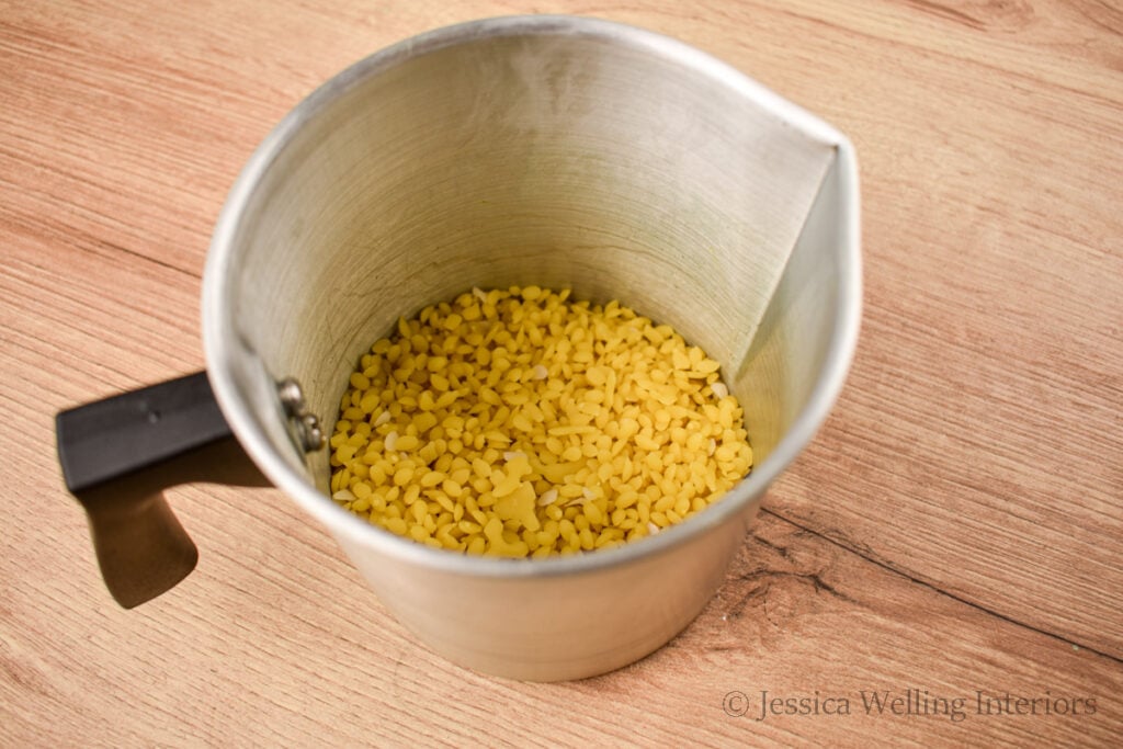 beeswax pastilles in a metal pitcher, ready to be melted down