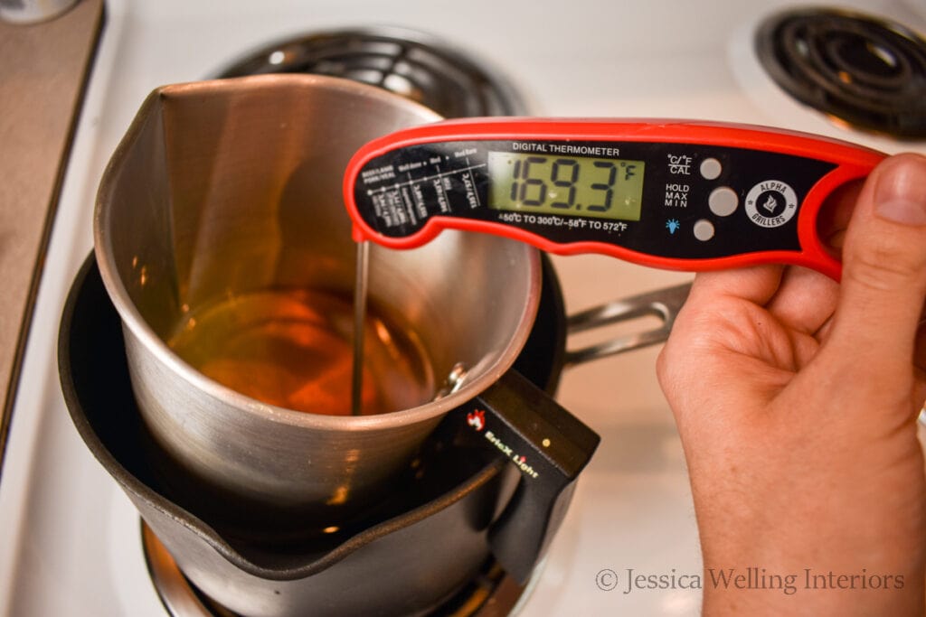 digital thermometer in a pitcher of melted beeswax