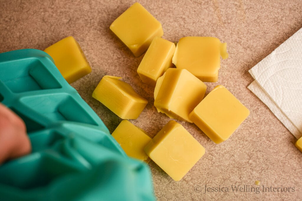 yellow beeswax melts being removed from a silicone mould