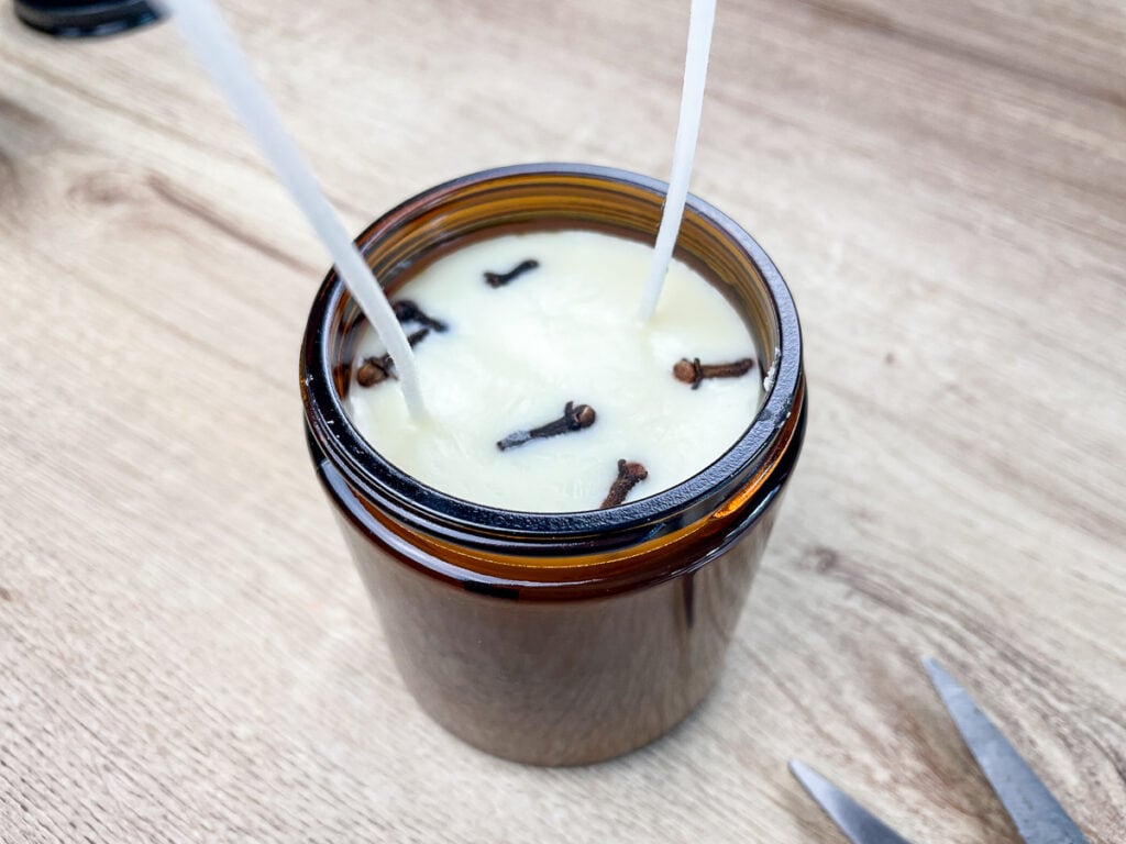 soy candle with hardened wax and two long wicks sticking up