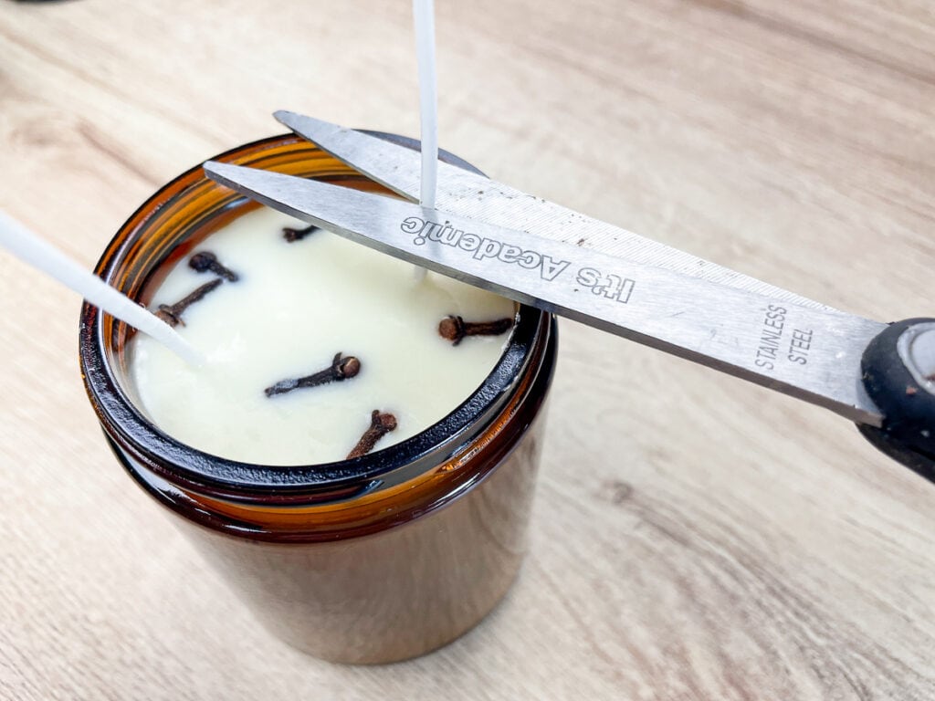 scissors cutting the wicks on a scented soy candle