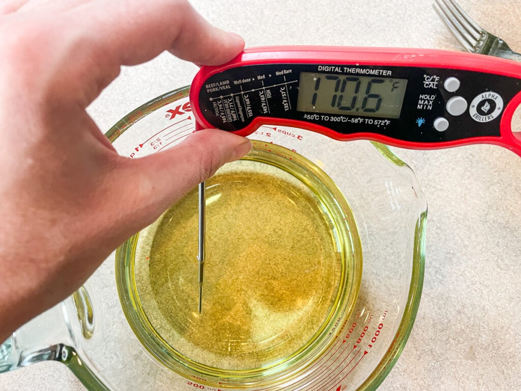 glass bowl of melted soy wax with a digital thermometer that reads 170 degrees