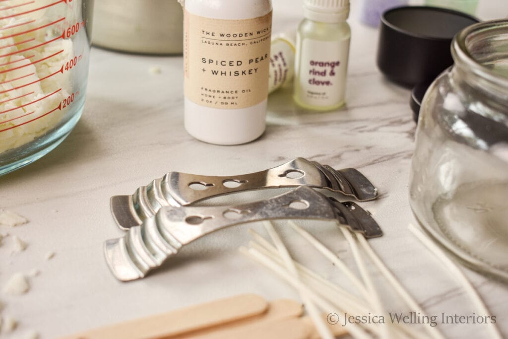 close-up photo of basic candle making supplies on a marble countertop