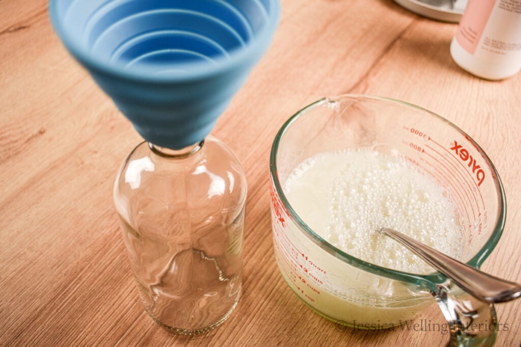 16 oz glass bottle with a funnel placed in the top, ready to be filled with homemade bubble bath