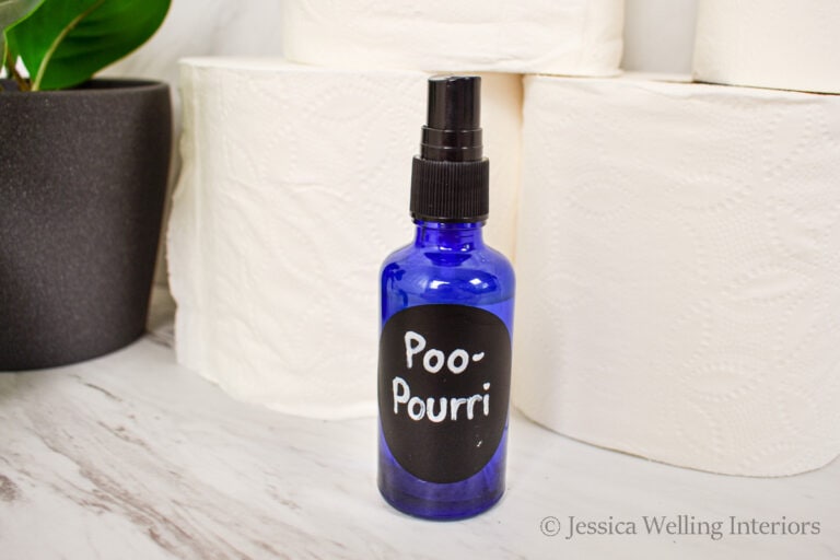 bottle of DIY Poo-Pourri Toilet Spray with rolls of toilet paper
