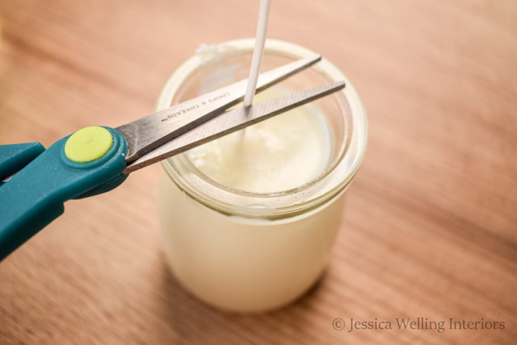 scissors trimming a cotton wick on a DIY soy candles