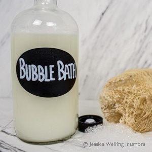 bottle of homemade bubble bath with a loofa sponge