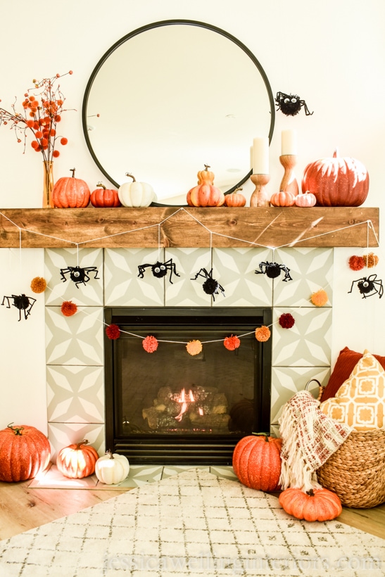 fireplace decorated for Fall with pumpkins, and warm throw blankets
