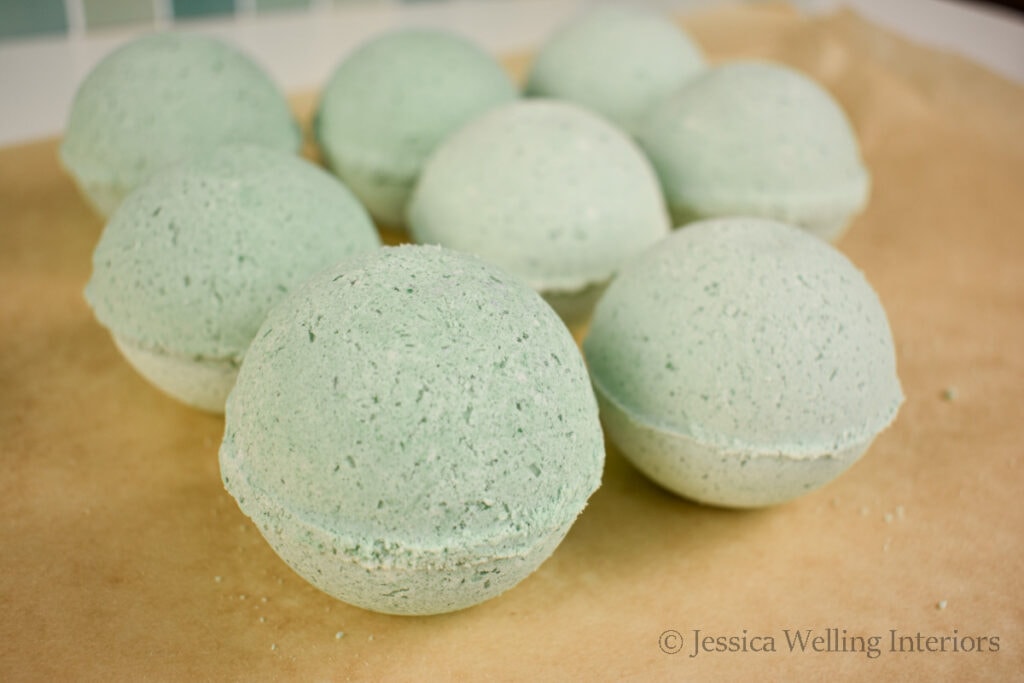 several homemade bath bombs drying on a sheet of parchment paper