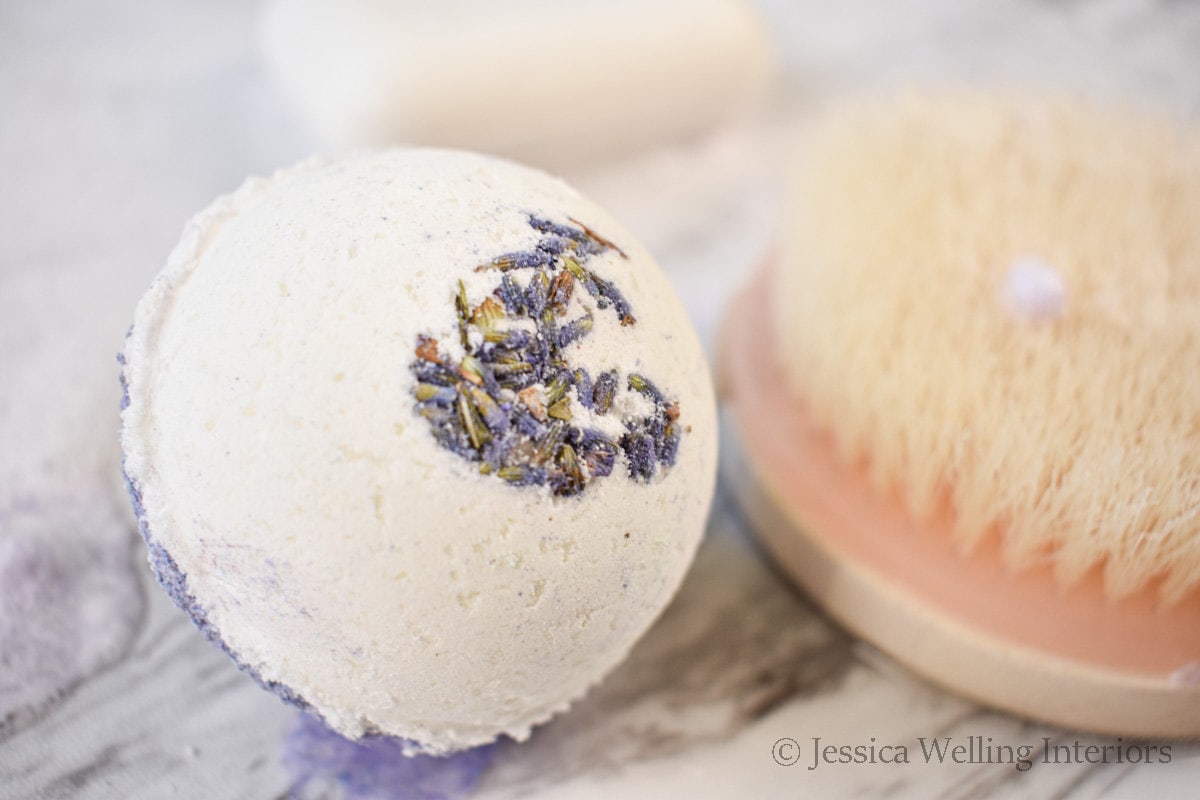 close-up of a bubble bath bomb with lavender flowers and a wood scrub brush