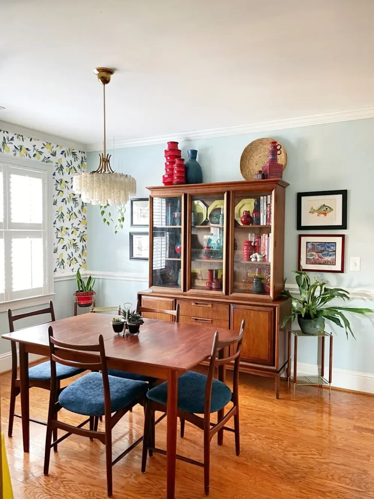 dining room with a yellow floral wallpaper accent wall
