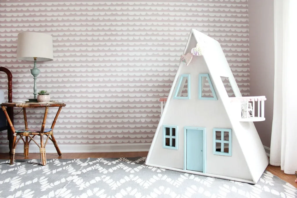 girls bedroom with a pink wave patterned wallpaper accent wall and a retro dollhouse