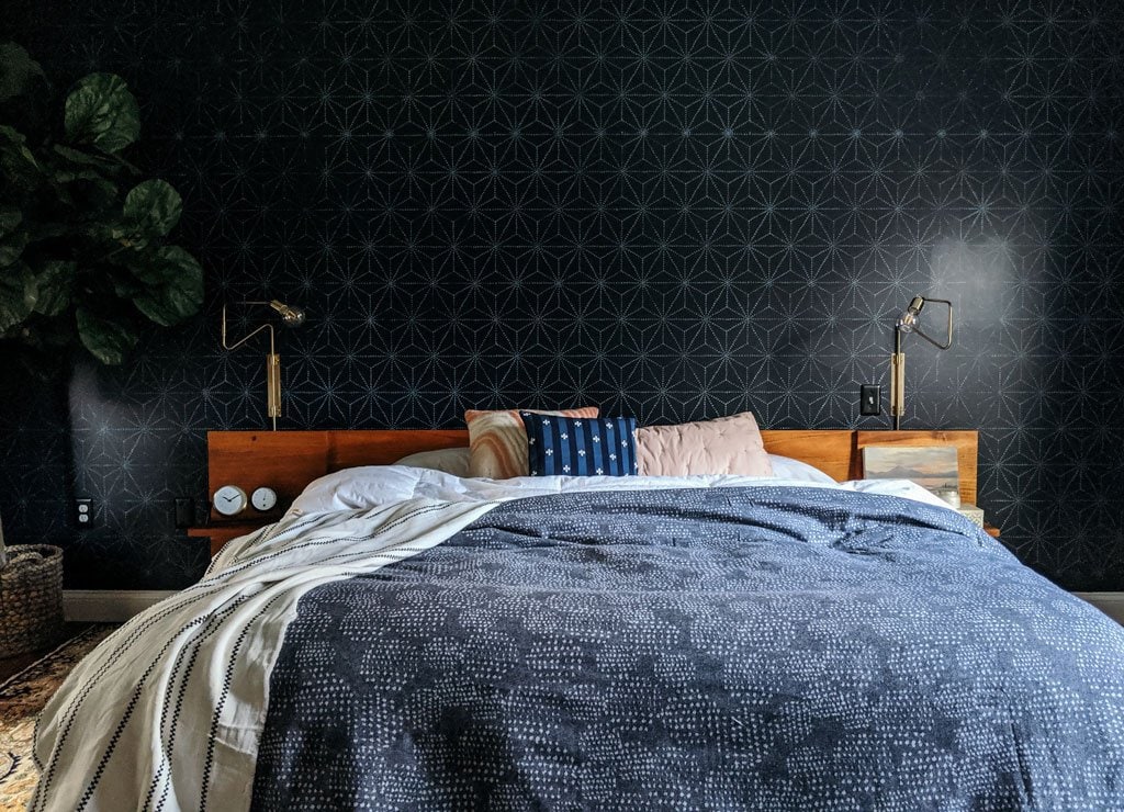 master bedroom with a black geometric stenciled accent wall behind the bed