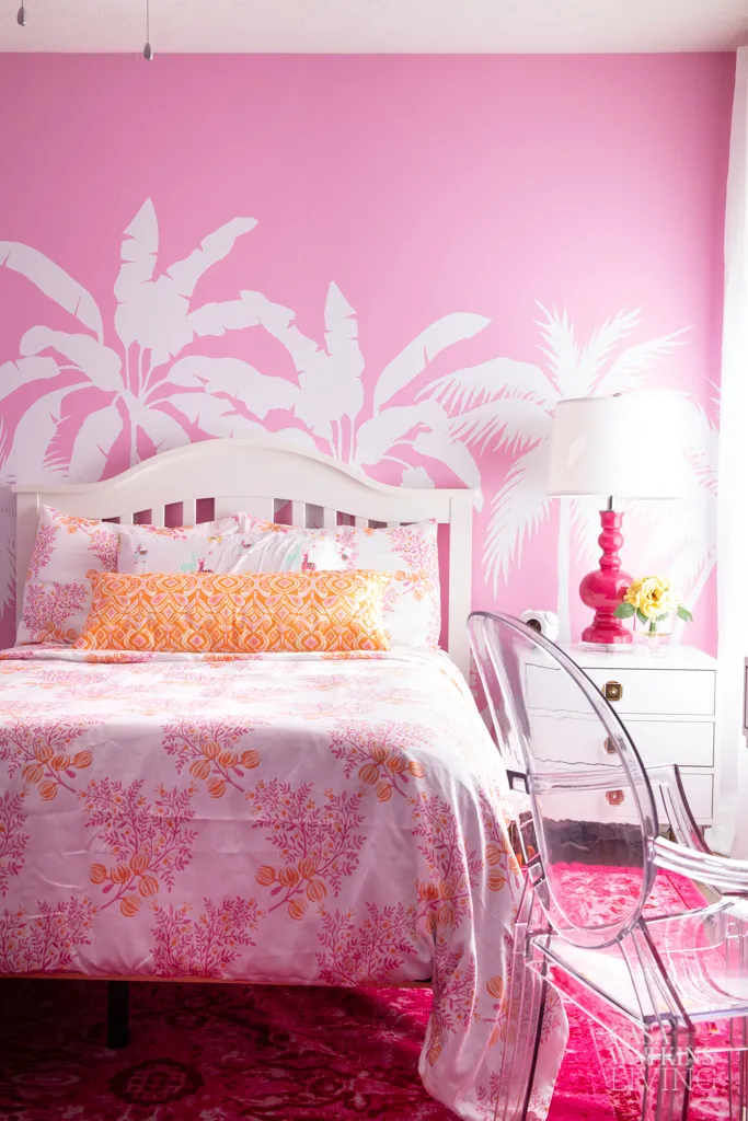 girls' bedroom with a pink palm tree mural behind the bed