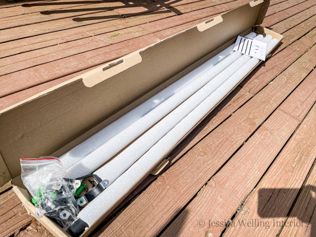 open box of deck string light pole components and mounting hardware