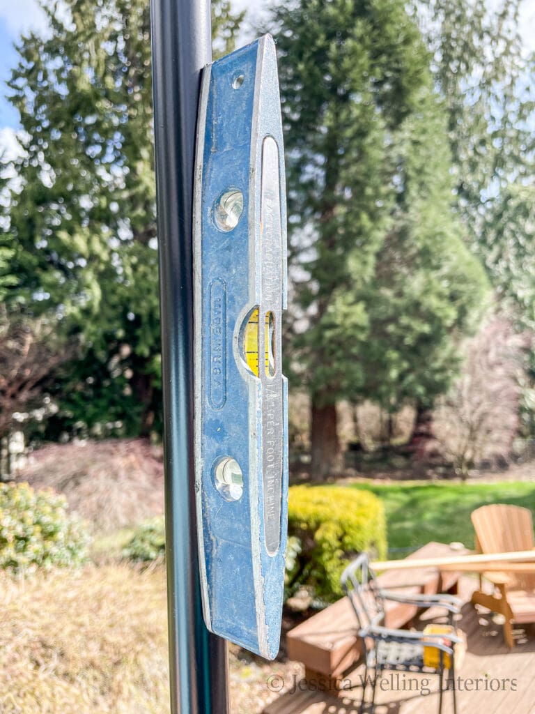 upright string light pole with a magnetic level next to it