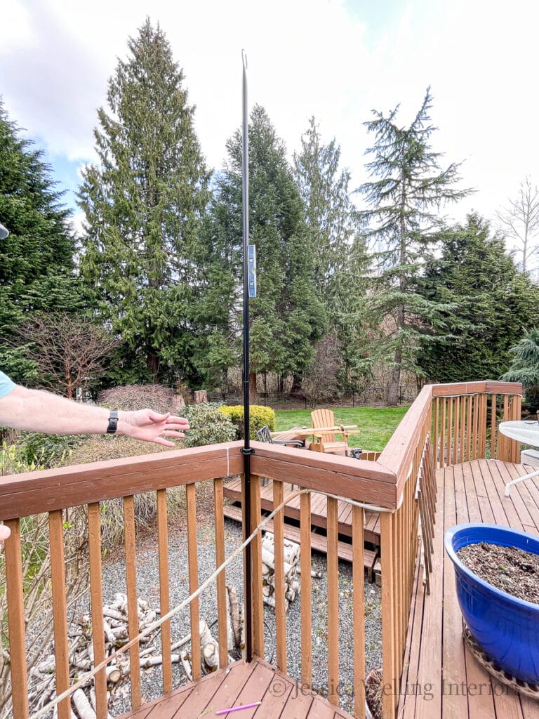 metal string light pole attached to a deck railing with brackets