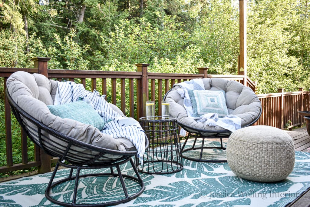 patio chat set with an outdoor rug and outdoor pouf on a deck