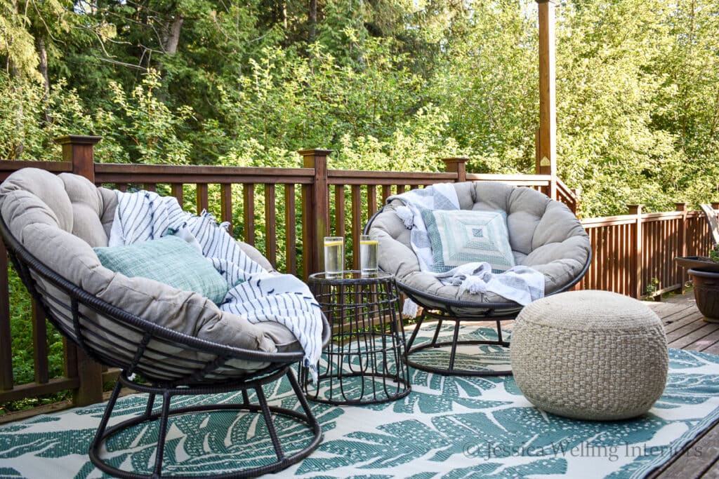 outdoor seating area on a deck with a green plastic outdoor rug