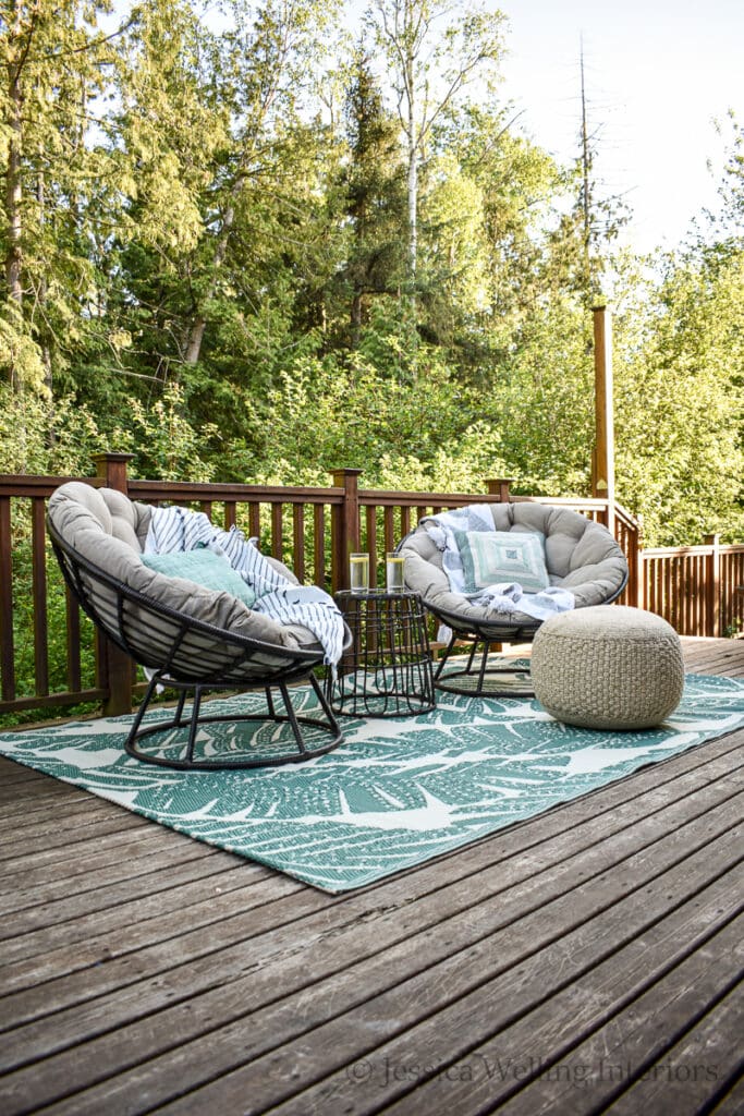 deck with a modern Boho outdoor seating area with two papasan chairs and an outdoor rug
